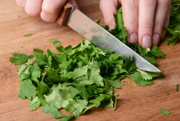 Chopped cilantro on wooden board close-up — Stock Photo, Image