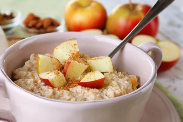 Sabrosa avena con manzanas y canela en la mesa de cerca — Foto de Stock