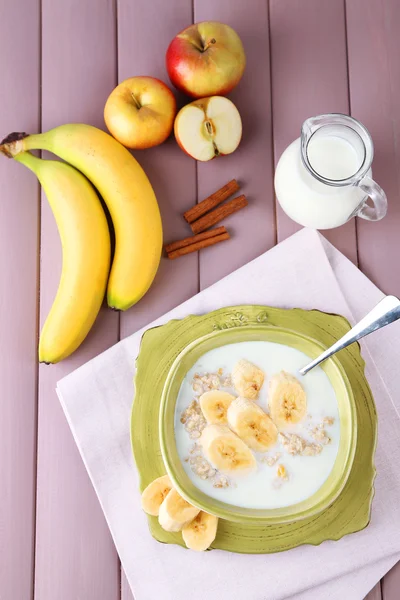 Fulgi de ovăz gustoși cu banane și lapte pe masă de lemn — Fotografie, imagine de stoc