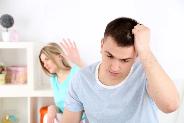 Retrato de joven hombre y mujer conflicto sentado en el sofá argumentar infeliz, en el fondo interior de casa — Foto de Stock