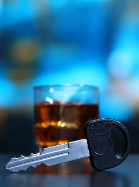 Komposition mit Autoschlüssel und Glas Whiskey, auf Holztisch, auf hellem Hintergrund — Stockfoto