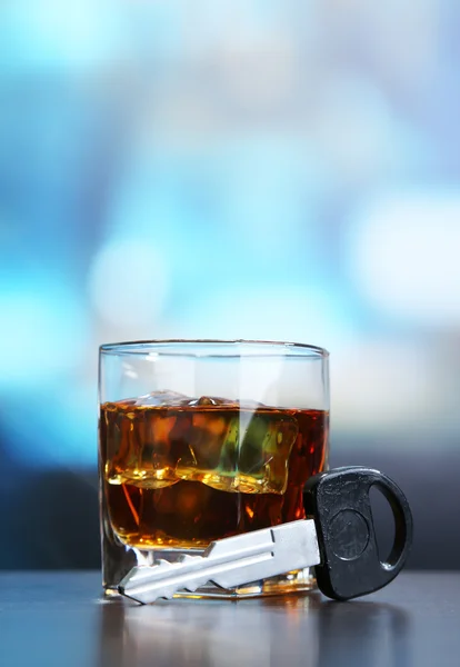 Composición con llave de coche y vaso de whisky, sobre mesa de madera, sobre fondo brillante — Foto de Stock