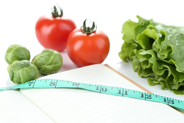 Book with measuring tape and vegetables isolated on white — Stock Photo, Image