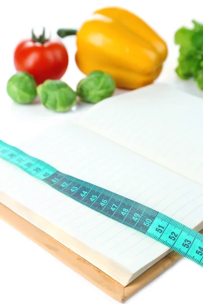 Book with measuring tape and vegetables isolated on white — Stock Photo, Image