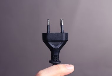 el elektrik fişi gri arka plan üzerinde tutarak