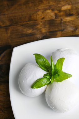 lezzetli mozzarella peyniri Fesleğenli ahşap zemin üzerinde plaka üzerinde