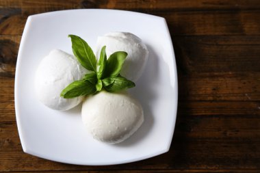 lezzetli mozzarella peyniri Fesleğenli ahşap zemin üzerinde plaka üzerinde