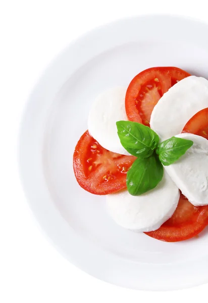 Caprese-Salat mit Mozarella, Tomaten und Basilikum auf Teller, isoliert auf weißem — Stockfoto