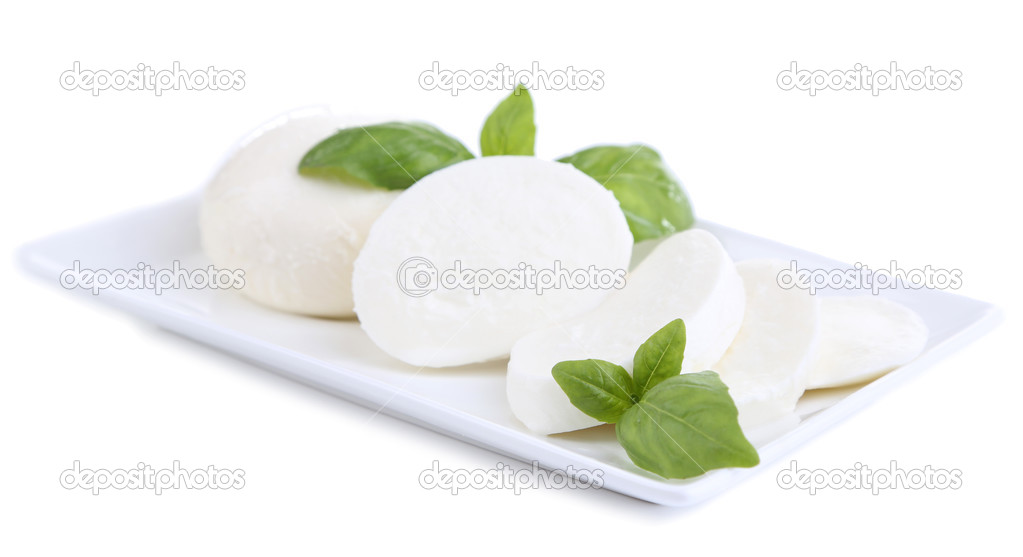 Tasty mozzarella cheese with basil on plate isolated on white