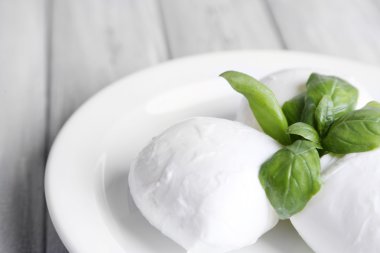 lezzetli mozzarella peyniri Fesleğenli ahşap zemin üzerinde plaka üzerinde