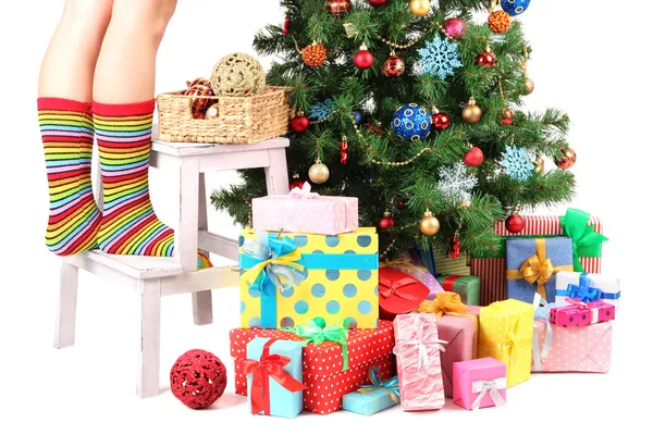 Patas femeninas en escalera de madera cerca del árbol de Navidad y regalos aislados en blanco —  Fotos de Stock