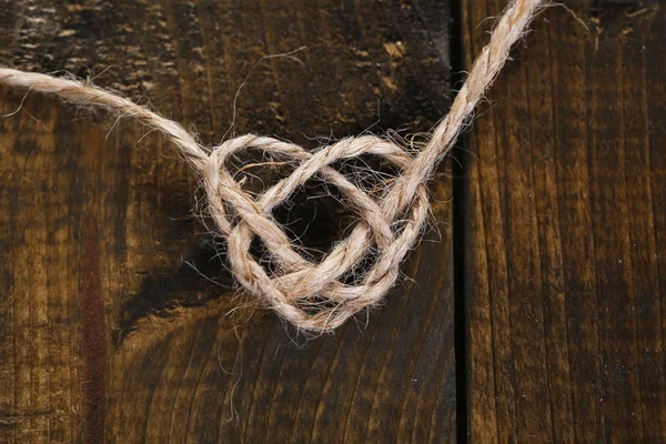 Heart shape from rope, on wooden background — Stock Photo, Image