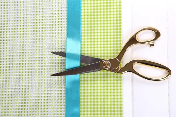 Scissors on color fabric background — Stock Photo, Image