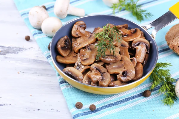 Вкусные жареные грибы в сковороде на столе крупным планом — стоковое фото