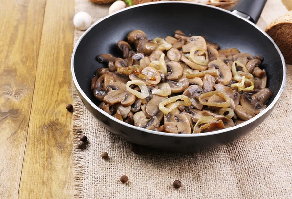 Heerlijke gebakken champignons in pan op tafel close-up — Stockfoto