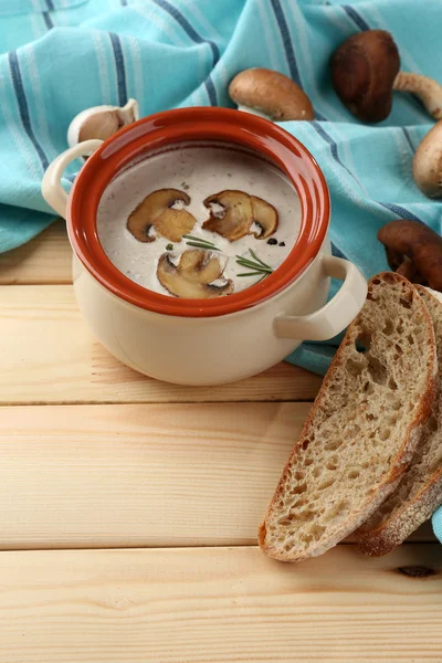 Houbová polévka v hrnci, na ubrousek, na dřevěné pozadí — Stock fotografie