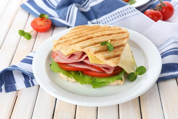 Tasty sandwich with ham on wooden table — Stock Photo, Image
