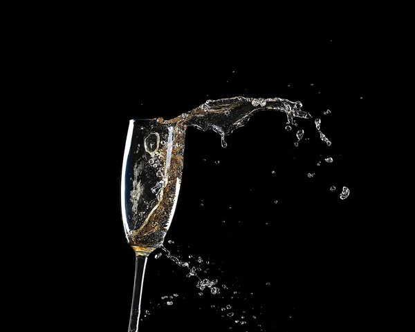 Verre de champagne avec éclaboussure, sur fond noir — Photo