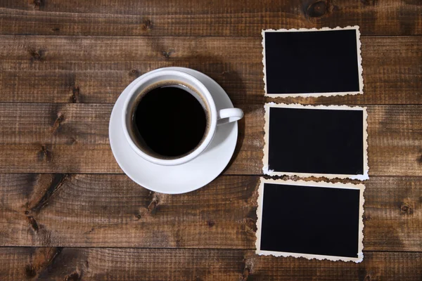 Taza de café y viejas fotos en blanco, sobre fondo de madera —  Fotos de Stock