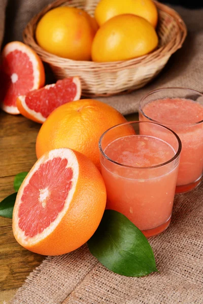 Стиглі грейпфрути з соком на столі крупним планом — стокове фото