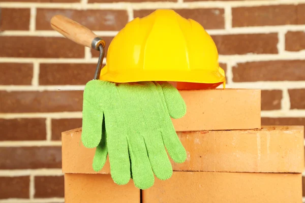 Nieuwe bakstenen en gebouw tools op bakstenen muur achtergrond — Stockfoto