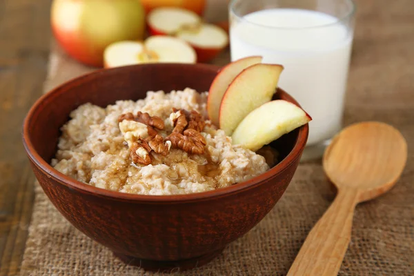 Sabrosa avena con nueces y manzanas sobre mesa de madera — Foto de Stock