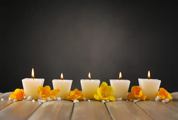 Schöne Kerzen mit Blumen auf Holzgrund — Stockfoto