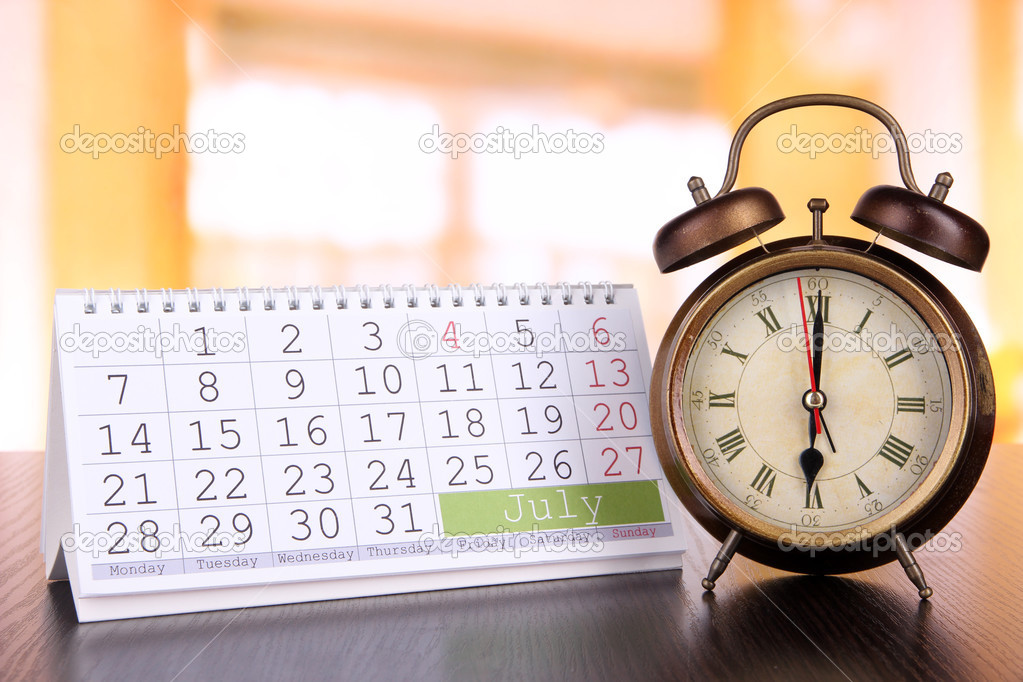 Alarm clock  and calendar on bright background