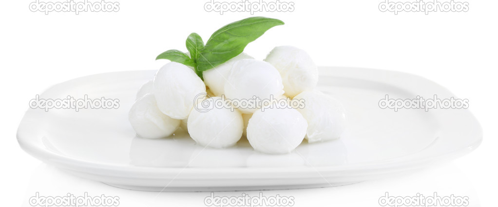 Tasty mozzarella cheese with basil on plate isolated on white