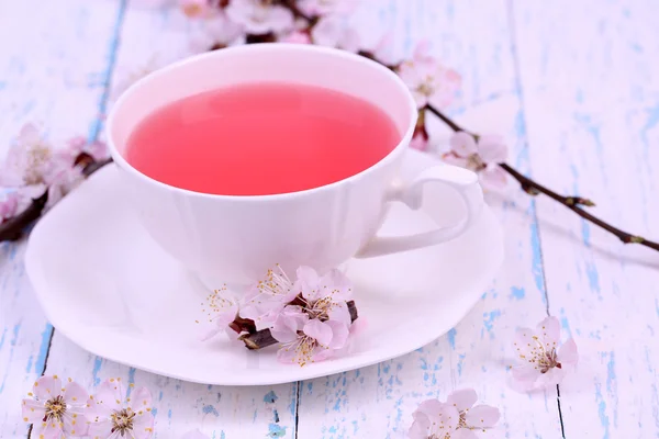 Fragrant tea with flowering branches on wooden table close-up — Stock Photo, Image