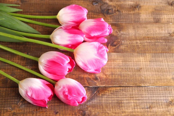 Hermosos tulipanes sobre fondo de madera color — Foto de Stock