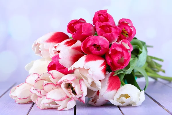 Красивые тюльпаны на деревянном столе, на светлом фоне — стоковое фото