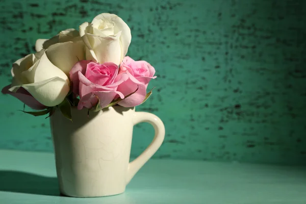 Vackra rosor i cup på grön bakgrund — Stockfoto