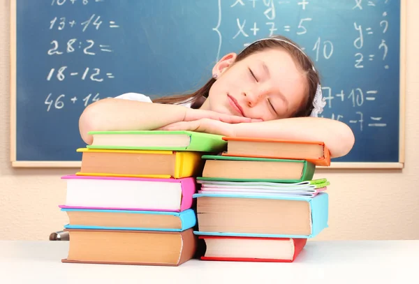 Little schoolgirl sleep in classroom near blackboard — Stock Photo, Image