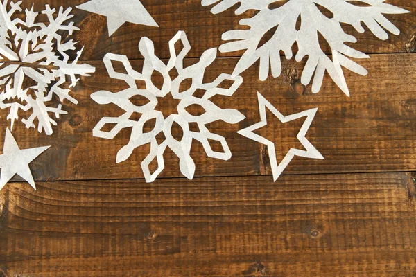 Beautiful paper snowflakes on wooden background — Stock Photo, Image