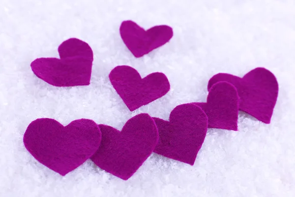 Pequeños corazones sentidos sobre fondo nevado — Foto de Stock