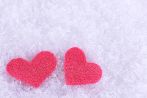 Pequenos corações sentidos no fundo nevado — Fotografia de Stock