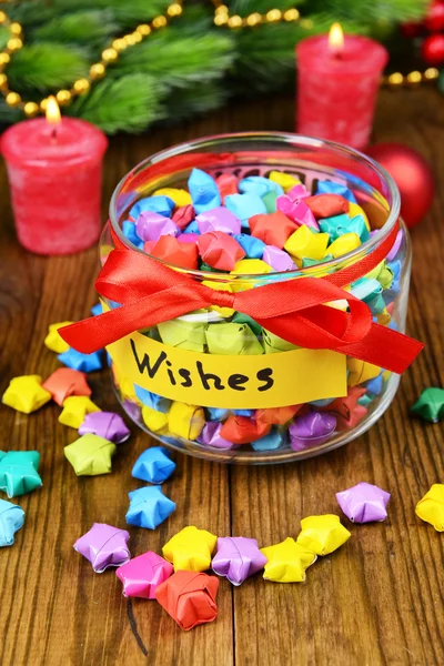Estrelas de papel com sonhos em jarra na mesa close-up — Fotografia de Stock