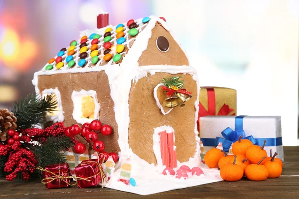 Schönes Lebkuchenhaus mit weihnachtlichem Dekor auf Holztisch — Stockfoto