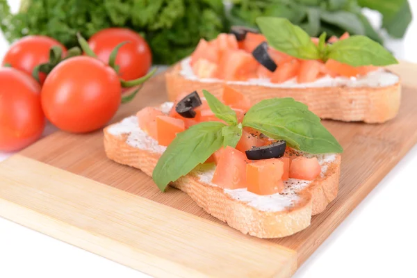 Lahodná bruschetta s rajčaty na řezací desce zblízka — Stock fotografie