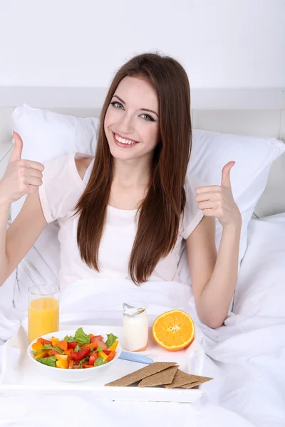 Young beautiful woman in bed with light breakfast — Stock Photo, Image