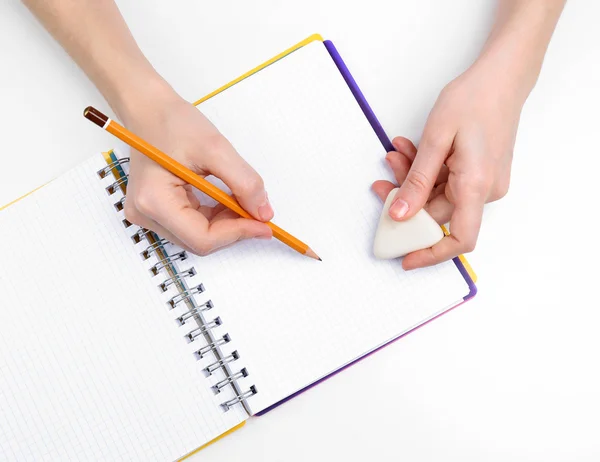 Manos humanas con lápiz y borrar goma y cuaderno, aislado en blanco —  Fotos de Stock