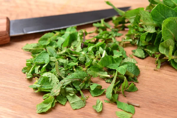 Chopped mint on wooden board close-up — Stock Photo, Image