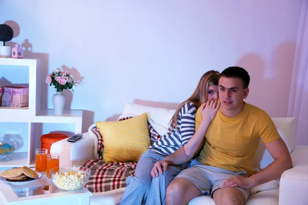 Giovane coppia guardando la televisione a casa di black-out — Foto Stock