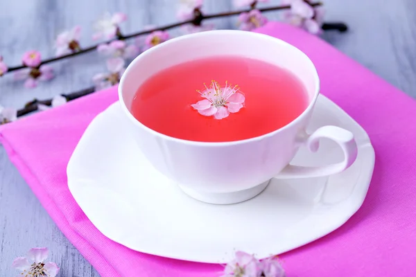 Fragrant tea with flowering branches on wooden table close-up — Stock Photo, Image