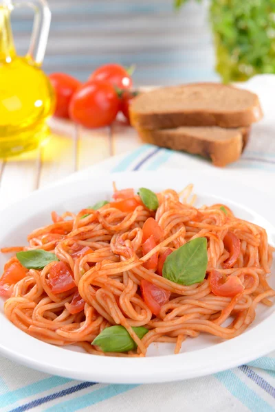 Massa com molho de tomate na placa na mesa no fundo claro — Fotografia de Stock