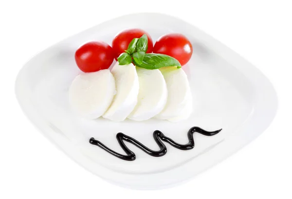 Caprese-Salat mit Mozarella, Tomaten und Basilikum auf Teller, isoliert auf weißem — Stockfoto