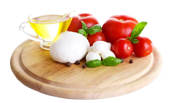 Samenstelling met smakelijke mozzarella kaas ballen, basilicum en rode tomaten, olijfolie op snijplank, geïsoleerd op wit — Stockfoto