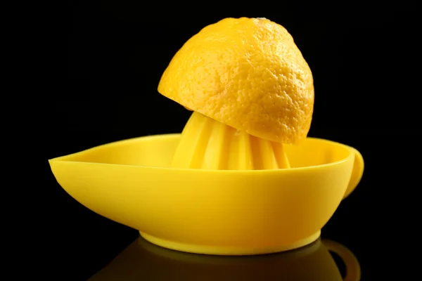 Exprimidor de cítricos con limón sobre fondo negro —  Fotos de Stock