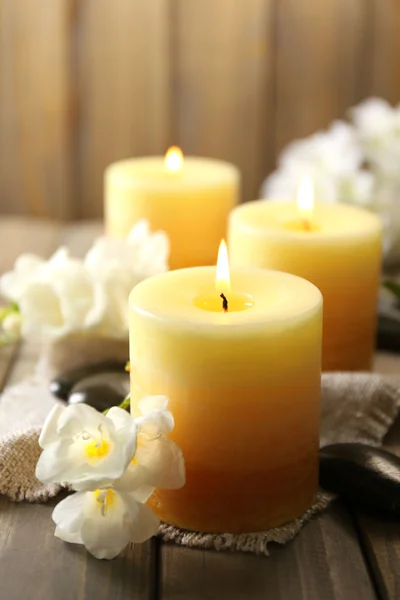 Beautiful candles with flowers on wooden background — Stock Photo, Image